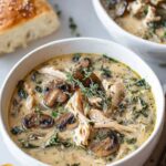 Rotisserie chicken mushroom soup in white bowl with fresh herbs garnish