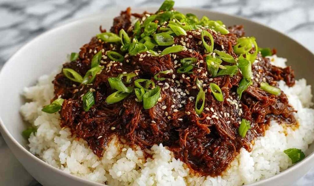 Slow Cooker Korean Beef served over white rice with green onions