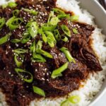 Slow Cooker Korean Beef served over white rice with green onions