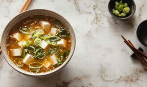 Vegan miso soup in ceramic bowl with tofu cubes and wakame seaweed