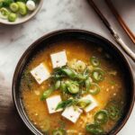 Vegan miso soup in ceramic bowl with tofu cubes and wakame seaweed