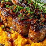 Apple Cider Pork with Mashed Sweet Potatoes plated with sauce and fresh thyme garnish