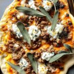 Autumn naan pizzas topped with sausage, caramelized shallots, and melted fontina cheese on baking sheet