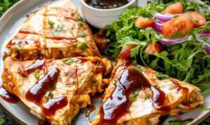 BBQ chicken quesadillas sliced into wedges on white plate with melted cheese