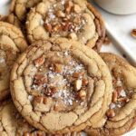 Brown Butter Coffee Toffee Cookies stacked on white plate with coffee cup
