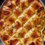 Chicken Pot Pie with Puff Pastry on white plate showing golden flaky crust and creamy filling