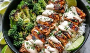 Chicken and broccoli bowls with creamy garlic sauce served over rice in white bowls