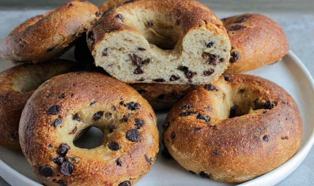 Chocolate chip bagels arranged on a cooling rack showing golden brown tops with melted chocolate chips