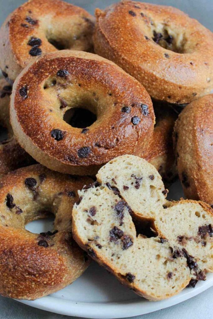 Chocolate chip bagels arranged on a cooling rack showing golden brown tops with melted chocolate chips