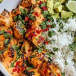Coconut chicken rice bowl with tender chicken pieces, jasmine rice, shredded carrots, cucumber, and cilantro garnish
