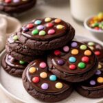 Fudgy cosmic brownie cookies topped with rainbow chocolate chips on cooling rack