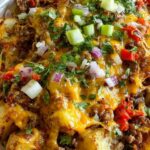 Slow cooker cowboy potato casserole with melted cheese and green onions