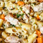 Creamy chicken pot pie pasta in a skillet with egg noodles and vegetables in rich white sauce