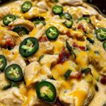 Creamy jalapeno chicken skillet with melted cheese in cast iron pan