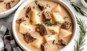 Bowl of creamy steak and potato soup with tender beef cubes