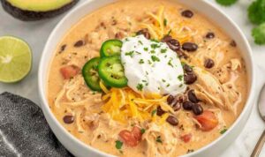 Crock Pot Cream Cheese Chicken Chili Bowl of crock pot cream cheese chicken chili topped with shredded cheese and cilantro