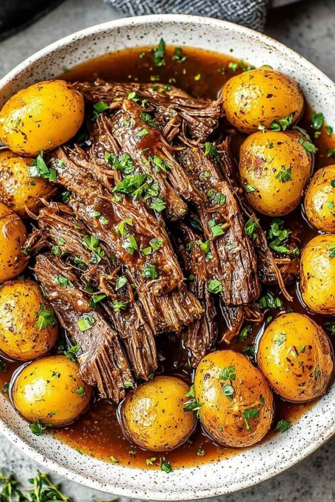 Tender Crock Pot Pot Roast with carrots and potatoes on white plate
