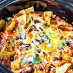 Crockpot Chicken Enchilada Casserole with melted cheese and cilantro garnish