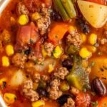 Crockpot Cowboy Soup in white bowl with ground beef beans and vegetables