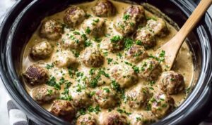 Crockpot Swedish meatballs in creamy gravy served over egg noodles with parsley garnish
