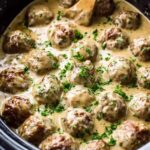 Crockpot Swedish meatballs in creamy gravy served over egg noodles with parsley garnish
