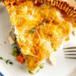 Easy chicken pot pie with golden flaky crust and creamy chicken filling on white plate