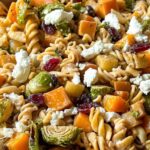 Fall pasta salad in white bowl with roasted sweet potatoes, bacon, apples, and cranberries