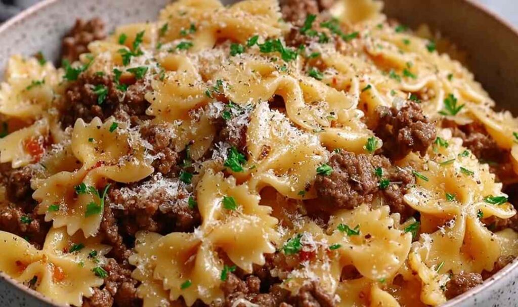 Garlic Butter Bowtie Pasta with Beef 5 Garlic butter bowtie pasta with beef served in white bowl with parmesan and parsley garnish