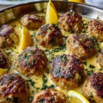 Greek meatballs in lemon sauce served over rice in white bowl with fresh herbs