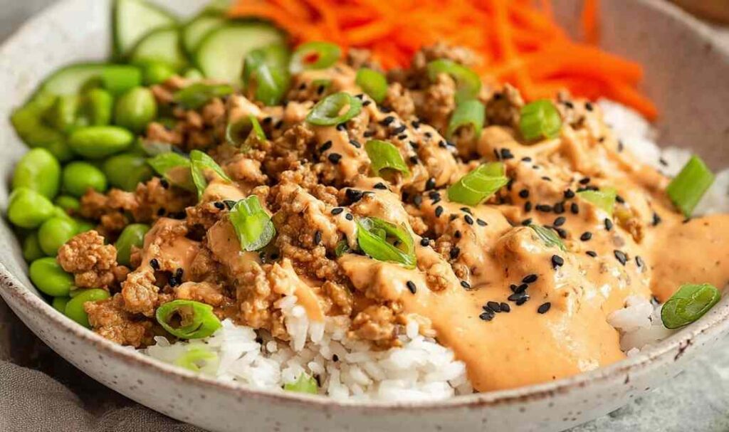 Ground turkey rice bowls with broccoli bell peppers and sesame seeds in white bowl
