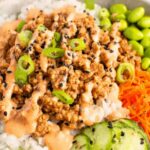 Ground turkey rice bowls with broccoli bell peppers and sesame seeds in white bowl