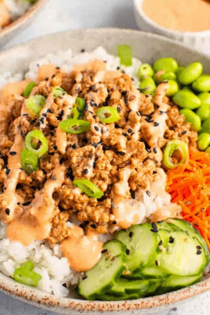 Ground turkey rice bowls with broccoli bell peppers and sesame seeds in white bowl
