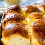 Golden brown milk brioche loaf fresh from the oven on cooling rack