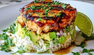 Honey Lime Chicken Avocado Rice Stack on white plate with lime wedges and cilantro garnish