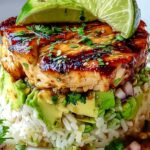 Honey Lime Chicken Avocado Rice Stack on white plate with lime wedges and cilantro garnish