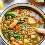 Bowl of Mediterranean lentil soup garnished with fresh parsley and served with crusty bread