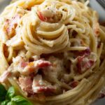 Michael Symon carbonara in white bowl with crispy guanciale and black pepper