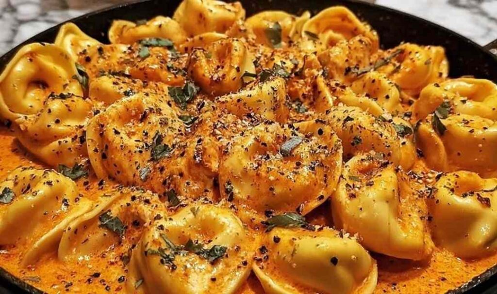 One Pot Spicy Garlic Butter Chicken Tortellini in a large pot with melted cheese and fresh parsley