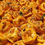 One Pot Spicy Garlic Butter Chicken Tortellini in a large pot with melted cheese and fresh parsley