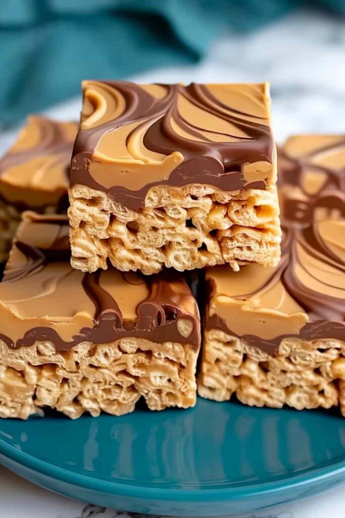 Peanut Butter Rice Krispie Treats 6 Peanut butter Rice Krispie treats stacked on white plate showing gooey texture