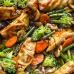Potsticker stir fry with crispy dumplings and colorful vegetables in skillet