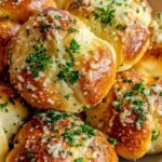 Quick sourdough garlic knots brushed with garlic butter on baking sheet