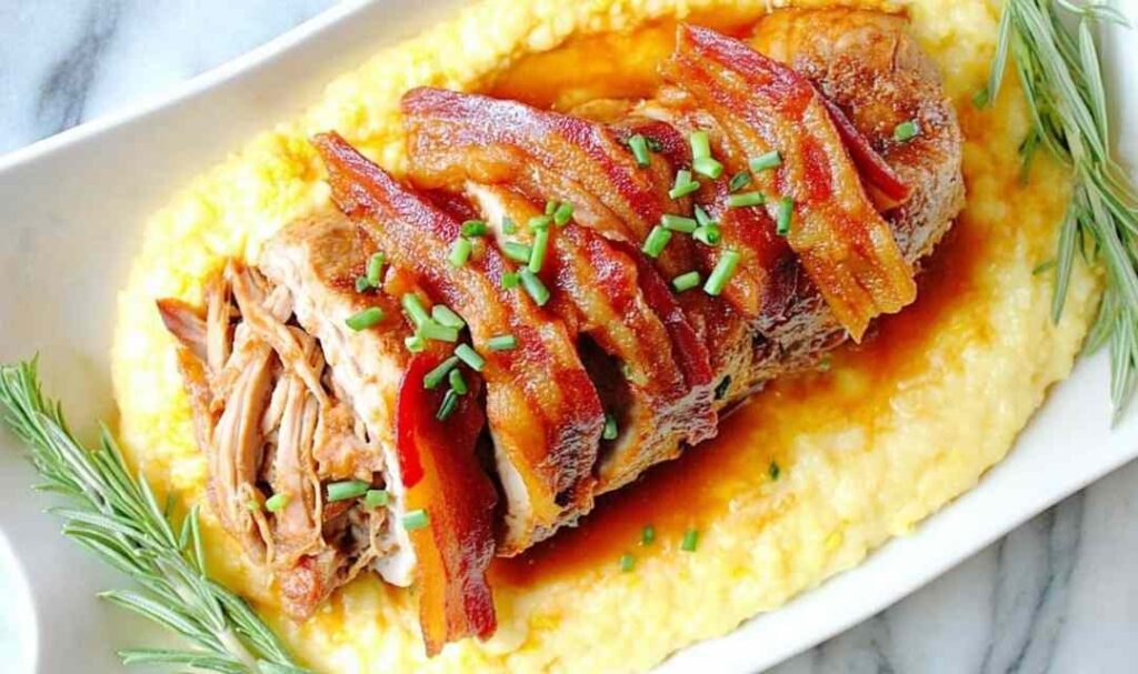 Sliced slow cooker apple butter glazed pork tenderloin on white platter with glaze drizzled on top