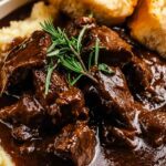 Slow Cooker Beef Manhattan served on white plate with shredded beef over mashed potatoes and toast covered in rich brown gravy
