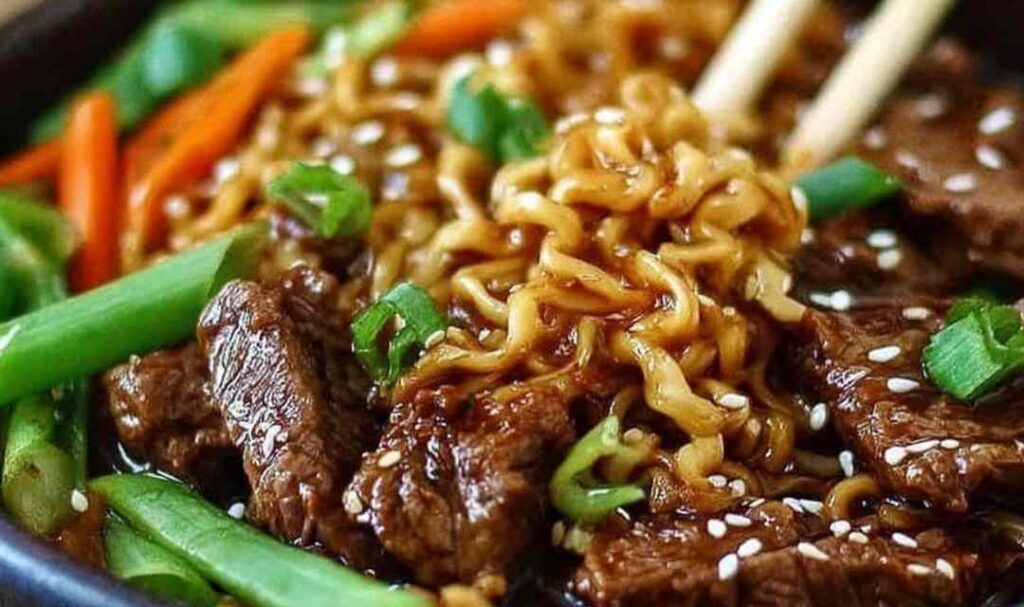 Bowl of slow cooker beef ramen noodles with tender beef chunks, green onions, and soft boiled egg