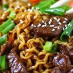 Bowl of slow cooker beef ramen noodles with tender beef chunks, green onions, and soft boiled egg