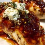 Slow cooker chicken with fig jam and goat cheese on white plate garnished with fresh thyme