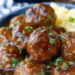 Slow cooker Salisbury steak meatballs in rich brown mushroom gravy served over creamy mashed potatoes