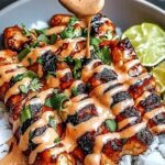 Sweet Chili Chicken Bowl with coconut lime drizzle served in white bowl with fresh vegetables and quinoa