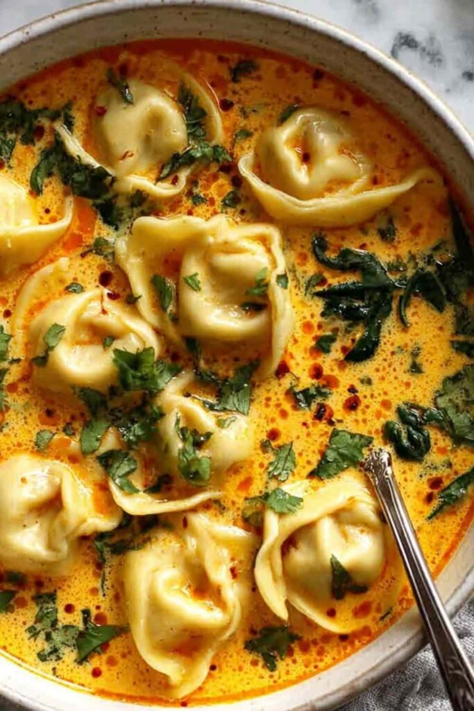 Thai Coconut Curry Dumpling Soup in white bowl garnished with cilantro and scallions